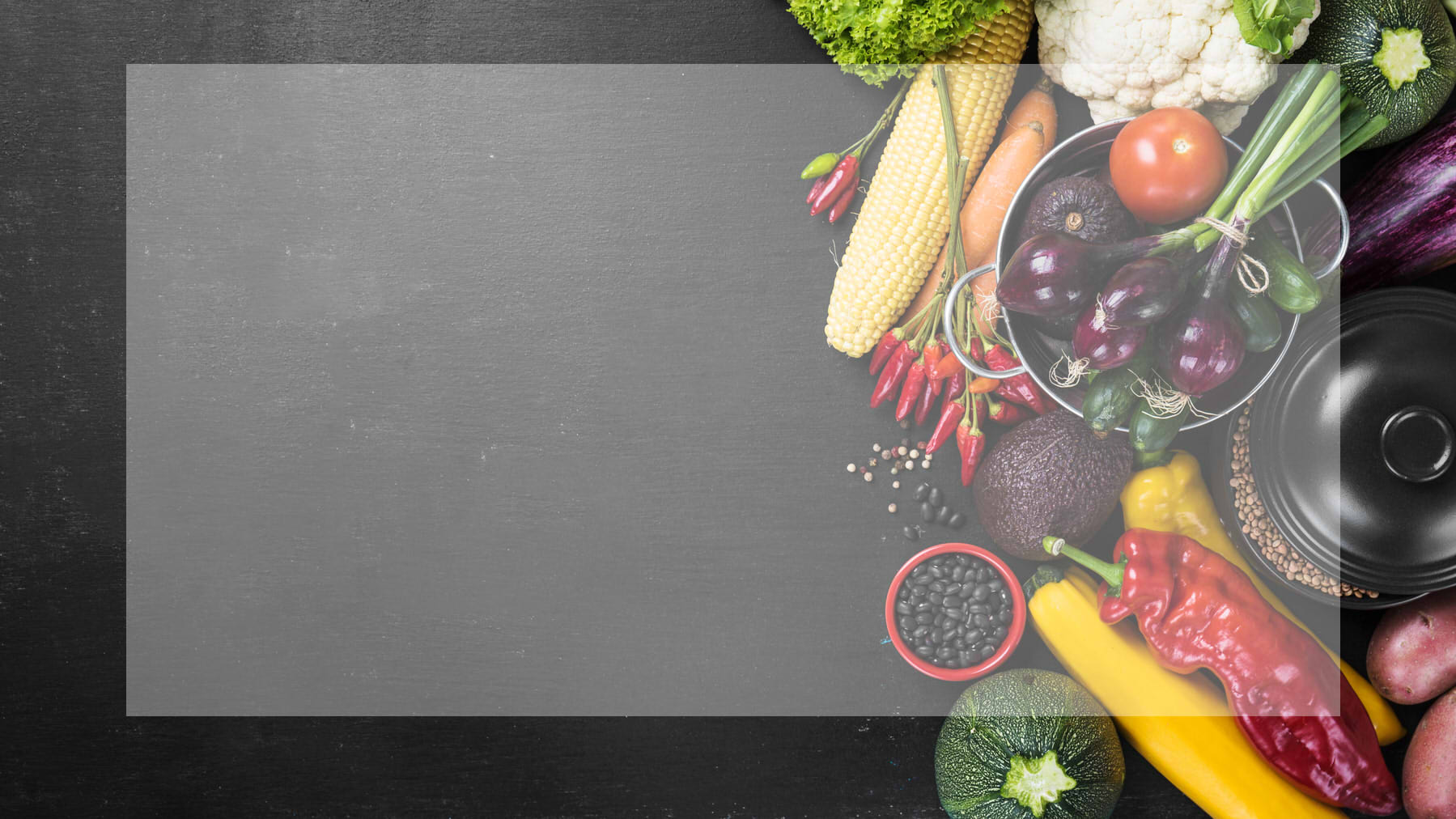 A slate board with various colorful vegetables on the right hand side of the board